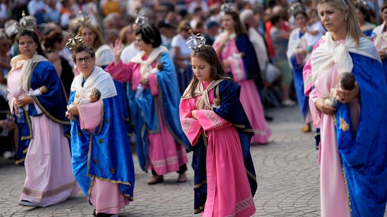 Women and girls dressed in pink and blue like the...