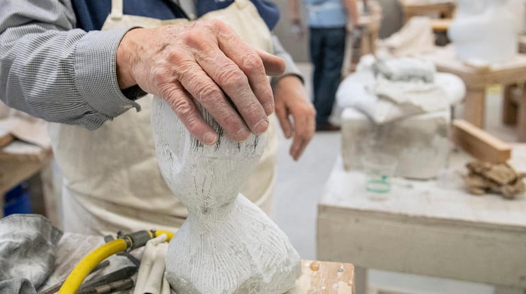 John Ditunno lays his hand on his unfinished piece during...