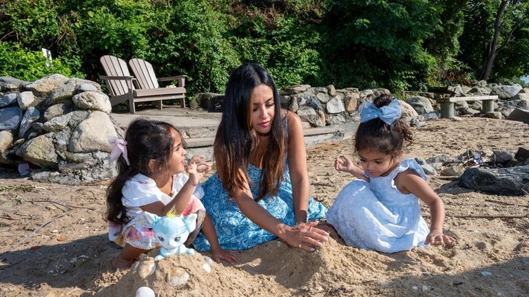 Leela, 5, and Mira Sarin, 3, participate in a beach...