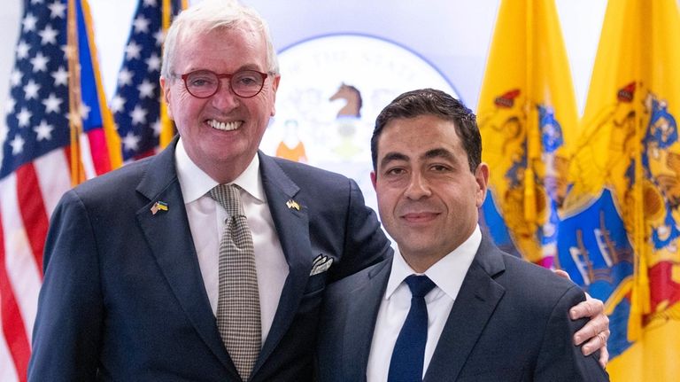 George Helmy, right, poses next to New Jersey Gov. Phil...