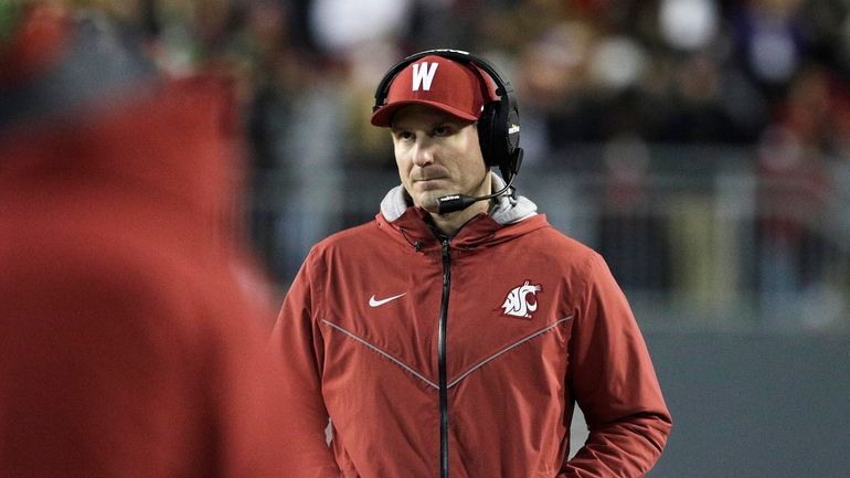 Washington State head coach Jake Dickert walks on the field...