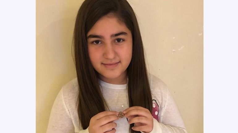 Kidsday reporter Stamatina Antzoulis holds her handmade clay cookie necklace.