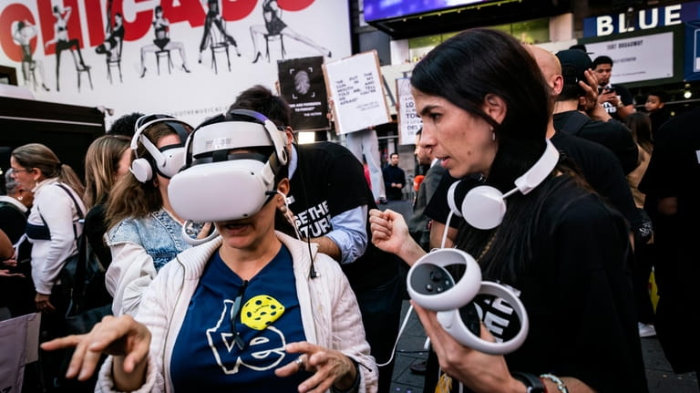 People standing near Times Square wear VR headsets screening an...