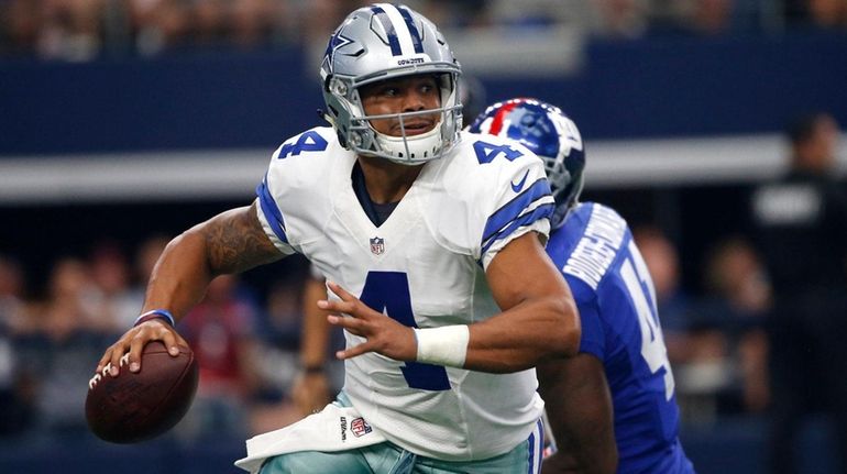 Dallas Cowboys quarterback Dak Prescott scrambles out of the pocket...