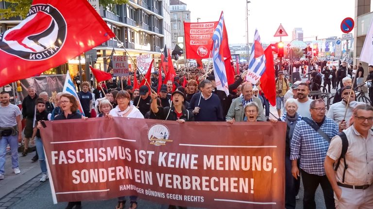 Participants in a demonstration against the right hold a banner...