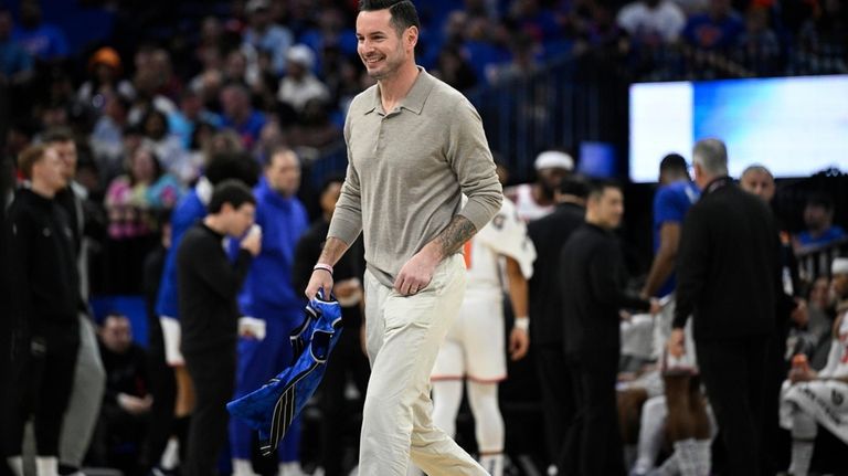 Former Orlando Magic guard JJ Redick, center, leaves the court...