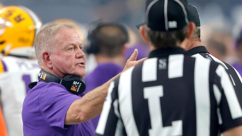 LSU head coach Brian Kelly, left, talks with officials during...