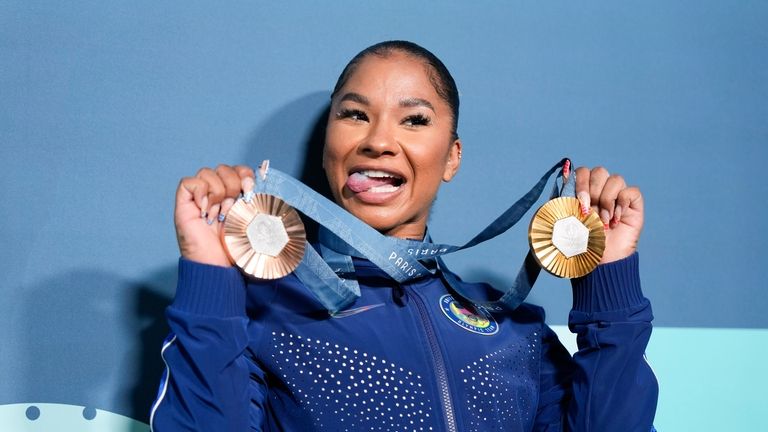 Jordan Chiles, of the United States, holds up her medals...