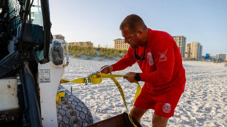 Patrick Brafford, a beach lifeguard manager, uses a tie down...