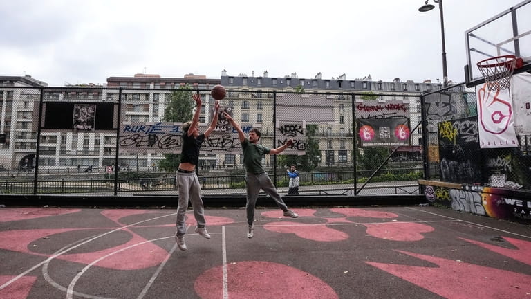 Youths play basketball at a court along the canal Saint...