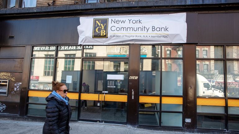 FILE- A person walks past a New York Community Bank...