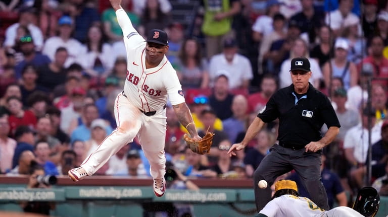 Boston Red Sox third base Rafael Devers, left, can't make...