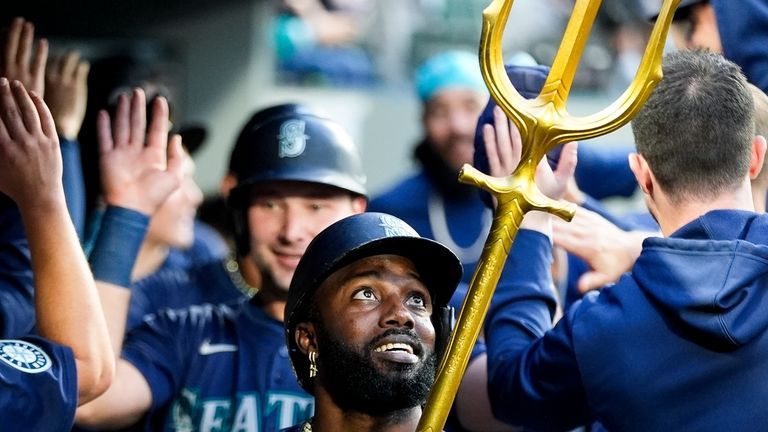 Seattle Mariners' Randy Arozarena looks up as he holds a...