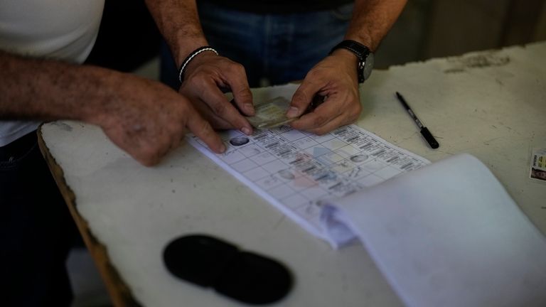 Election officials tally the votes after polls closed for the...