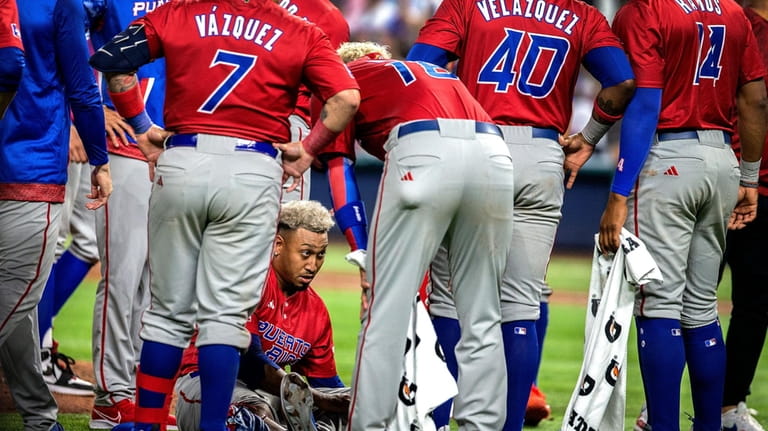 Puerto Rico pitcher Edwin Diaz sits on the ground after...