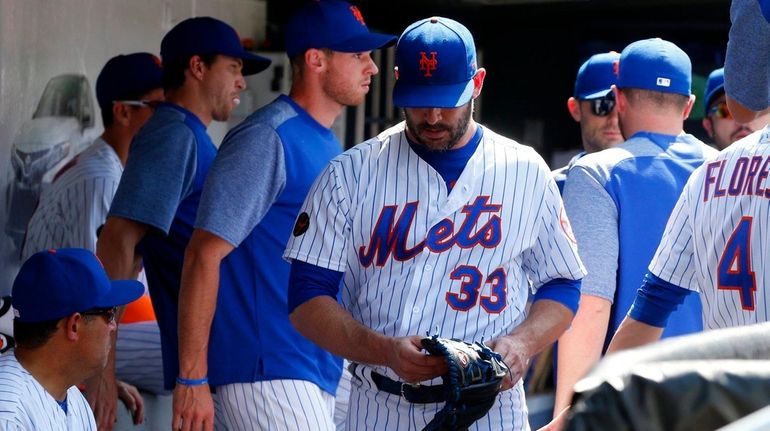 Matt Harvey of the Mets walks through the dugout after...