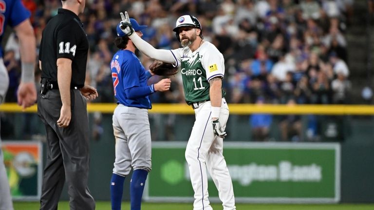 Colorado Rockies' Jake Cave (right) celebrates after hitting a double...