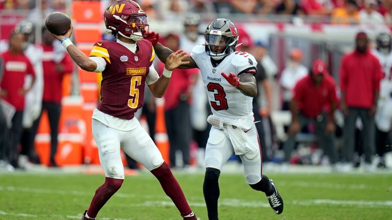 Washington Commanders quarterback Jayden Daniels (5) throws a pass as...