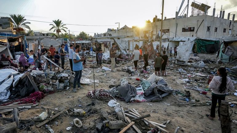 Palestinians inspect the damage at a tent area in the...