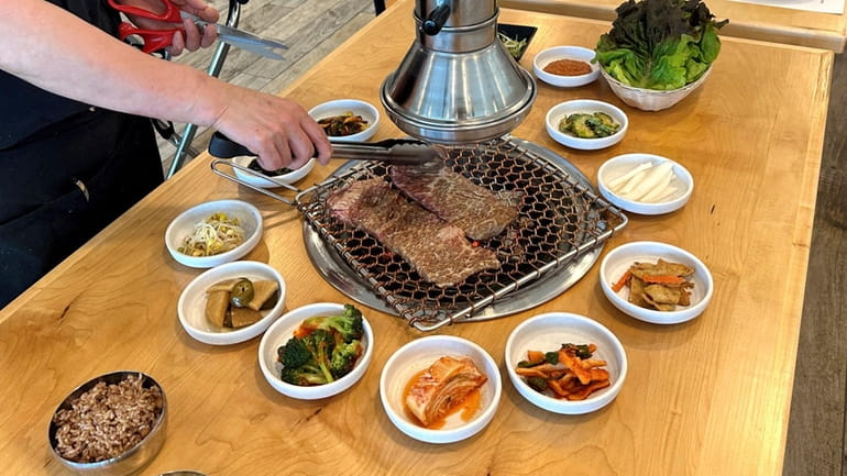 Galbi (sliced short rib) is grilled at the table at...