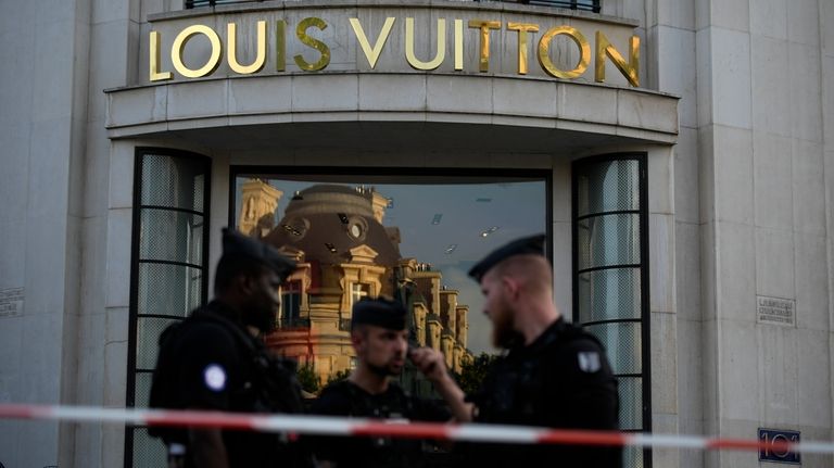 Police officers stand guard at the Louis Vuitton store on...