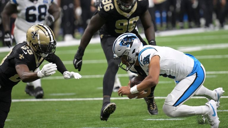 Carolina Panthers quarterback Bryce Young, right, dives into the end...