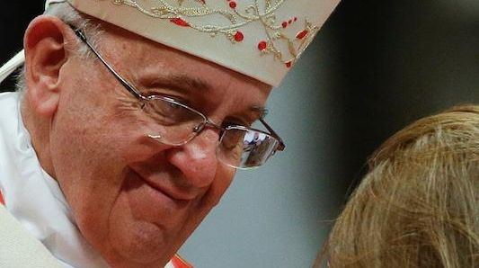 Pope Francis with a baby at a Mass where he...