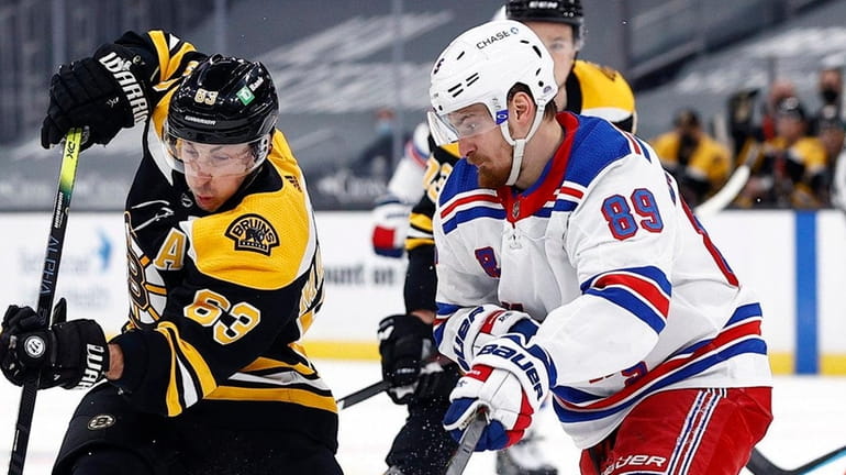 Brad Marchand of the Bruins skates against Pavel Buchnevich of the...