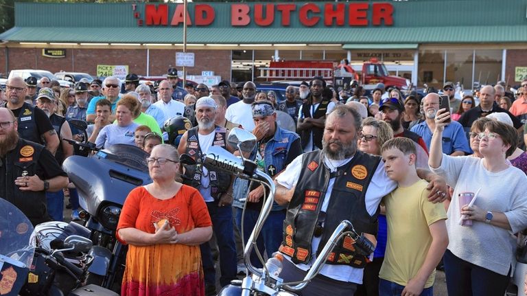 Mourners gather for a candlelight vigil in the parking lot...