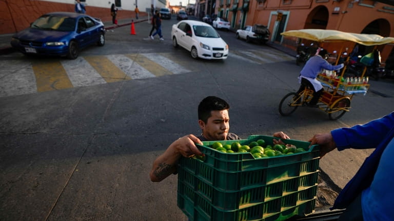 A man loads lemon onto a truck in Maravatio, Michoacan...