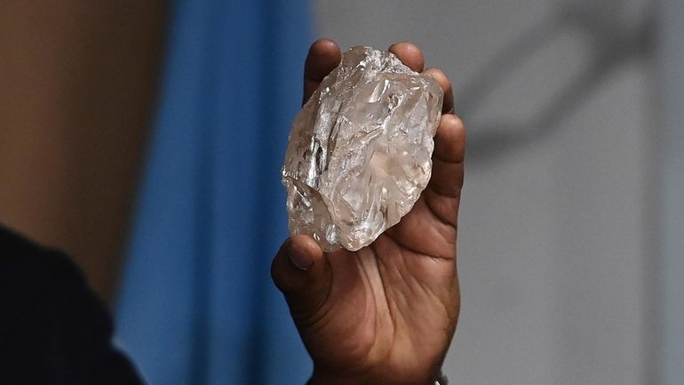 A person holds a 2,492-carat diamond which was found in...