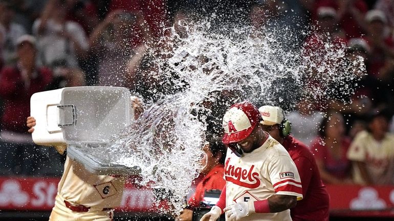 Los Angeles Angels' Willie Calhoun, is hit with water by...