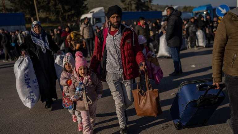 Syrians cross into their country from the Turkish crossing point...