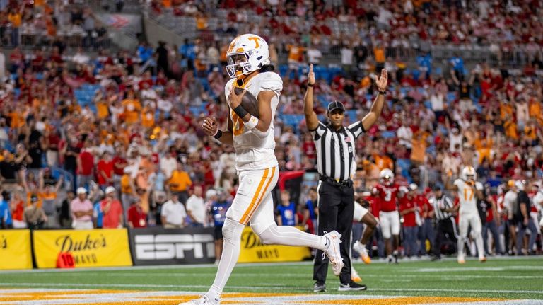 Tennessee quarterback Nico Iamaleava (8) scores against North Carolina State...