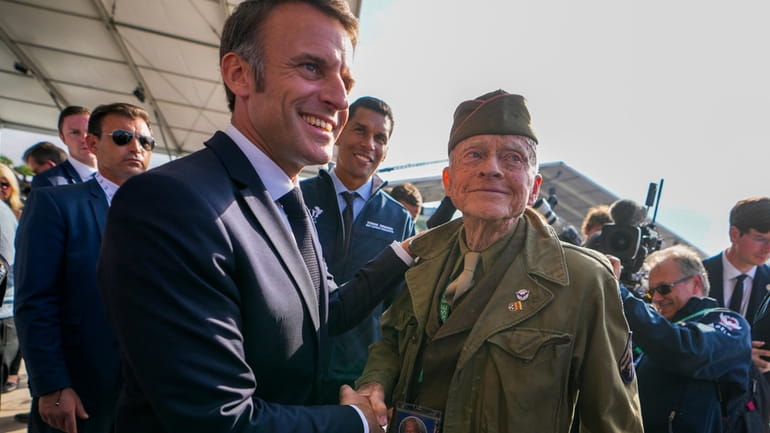 French President Emmanuel Macron, left, shakes hands with U.S. WWII...