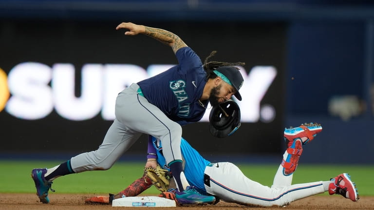 Seattle Mariners shortstop J.P. Crawford, left, is unable to tag...
