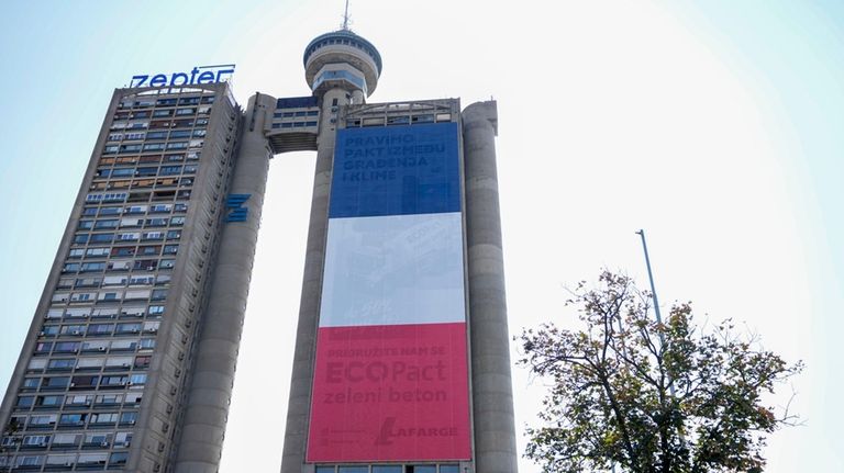 A giant French national flag on a skyscraper that is...