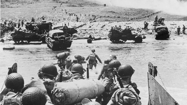 American soldiers and supplies arrive on the shore of the...