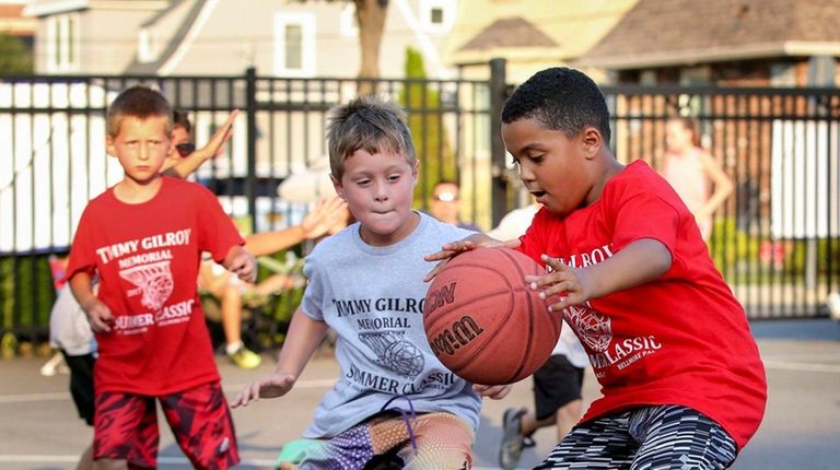 Ivan Adames, 8, right, dribbles past Sammy Johnson, center, during...