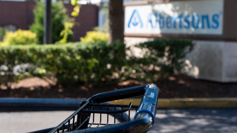 A grocery cart rests in a cart return area with...