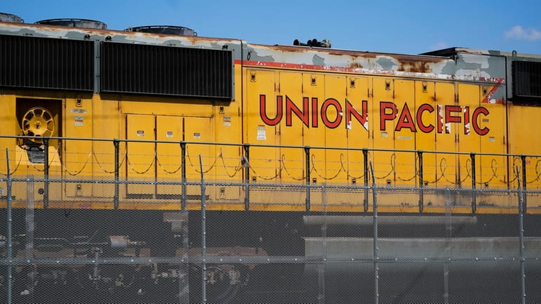 A Union Pacific train engine sits in a rail yard...
