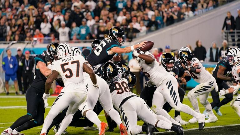 Jacksonville Jaguars quarterback Trevor Lawrence (16) jumps for a touchdown...