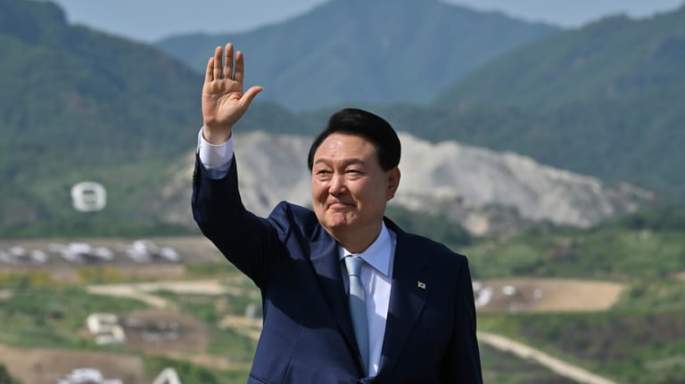 South Korean President Yoon Suk Yeol waves as he delivers...