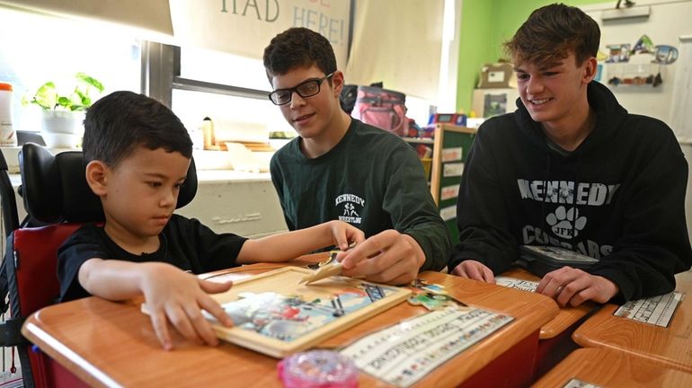 Cole Wasserman, 17, right, and Maxwell Frank, 16, center, designed...