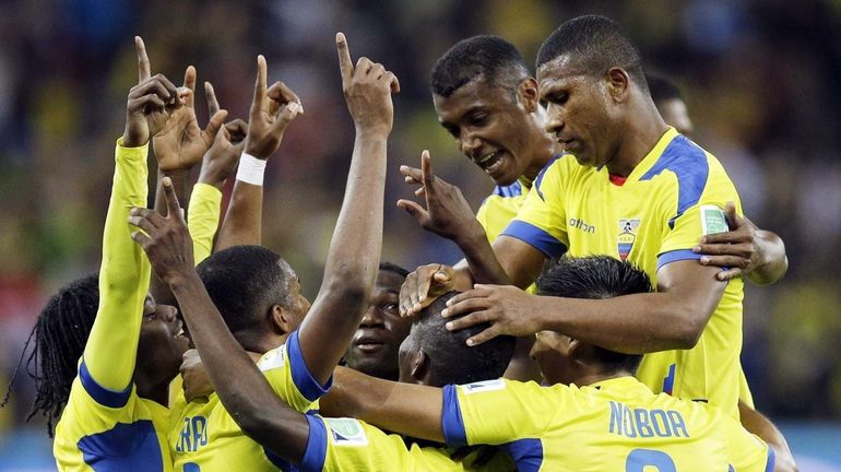 Ecuador's Enner Valencia, center, celebrates with teammates after scoring his...