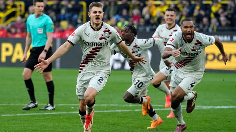 Leverkusen's Josip Stanisic, left, celebrates after scoring in the last...