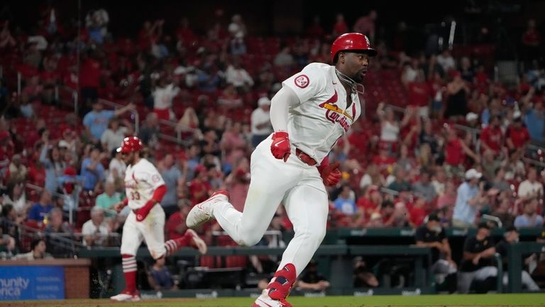 St. Louis Cardinals' Jordan Walker, right, rounds first on his...