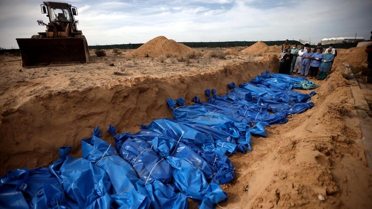 Palestinians pray over bodies of people killed in the Israeli...