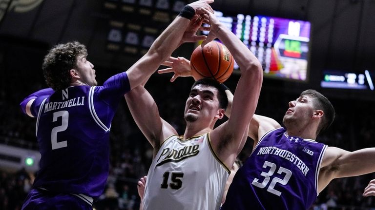 Purdue center Zach Edey (15) is fouled between Northwestern Wildcats...