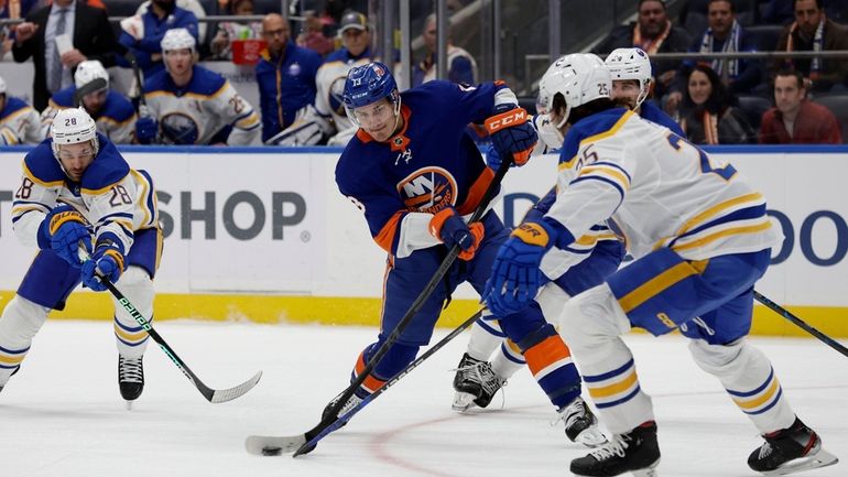 Mathew Barzal #13 of the New York Islanders attempts a...